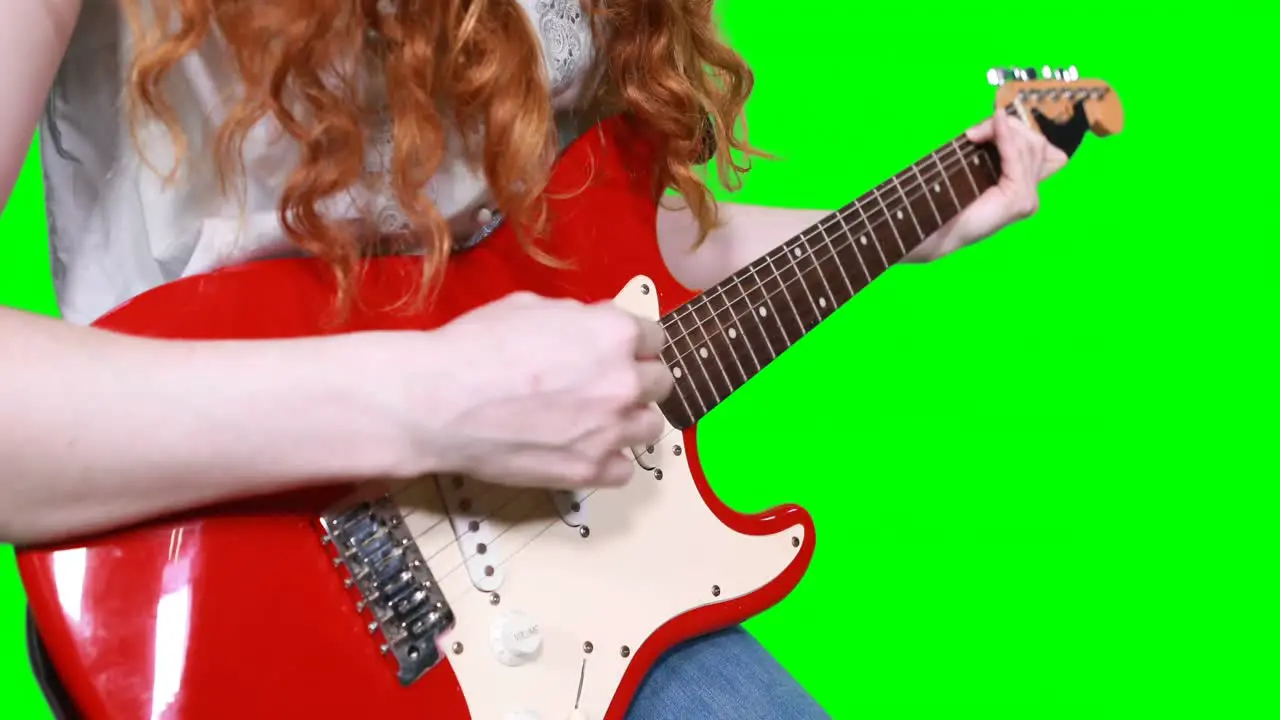 Mid section of female musician playing guitar