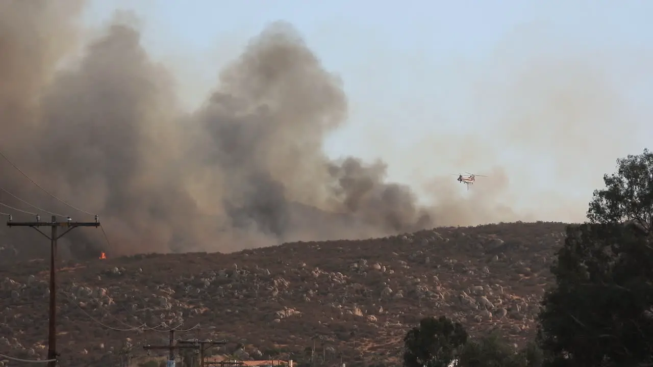 Helicopter dropping a huge load of water into Fairview Fire with clouds of smoke blocking the sight