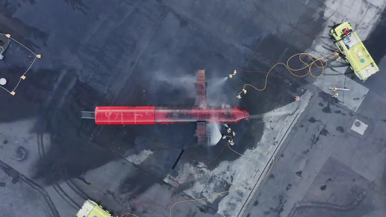 Firemen dousing engine fire on dummy airplane during annual training in Iceland