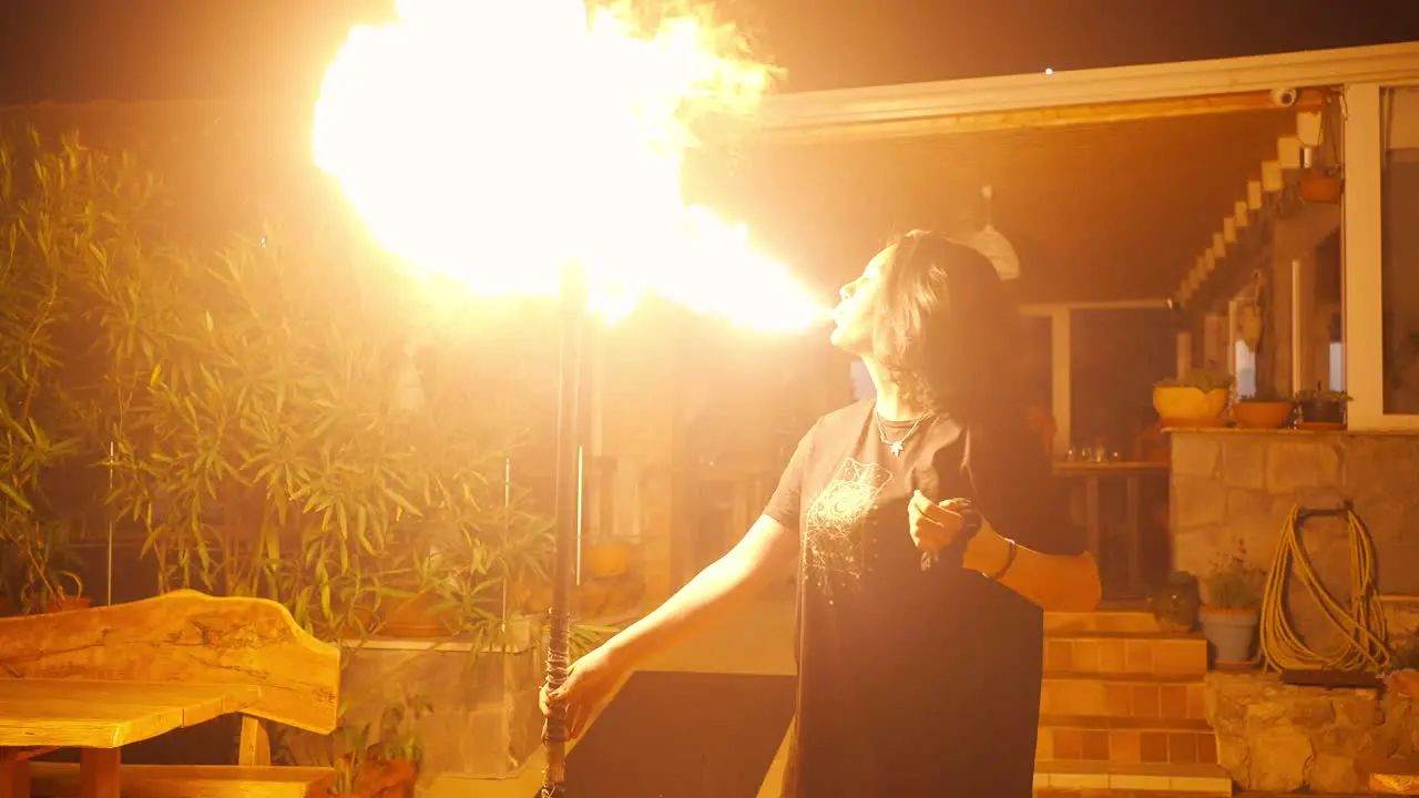 Young Female Fire Blower Fire-eater Blowing Gasoline on Torch Making Big Flames Slow Motion