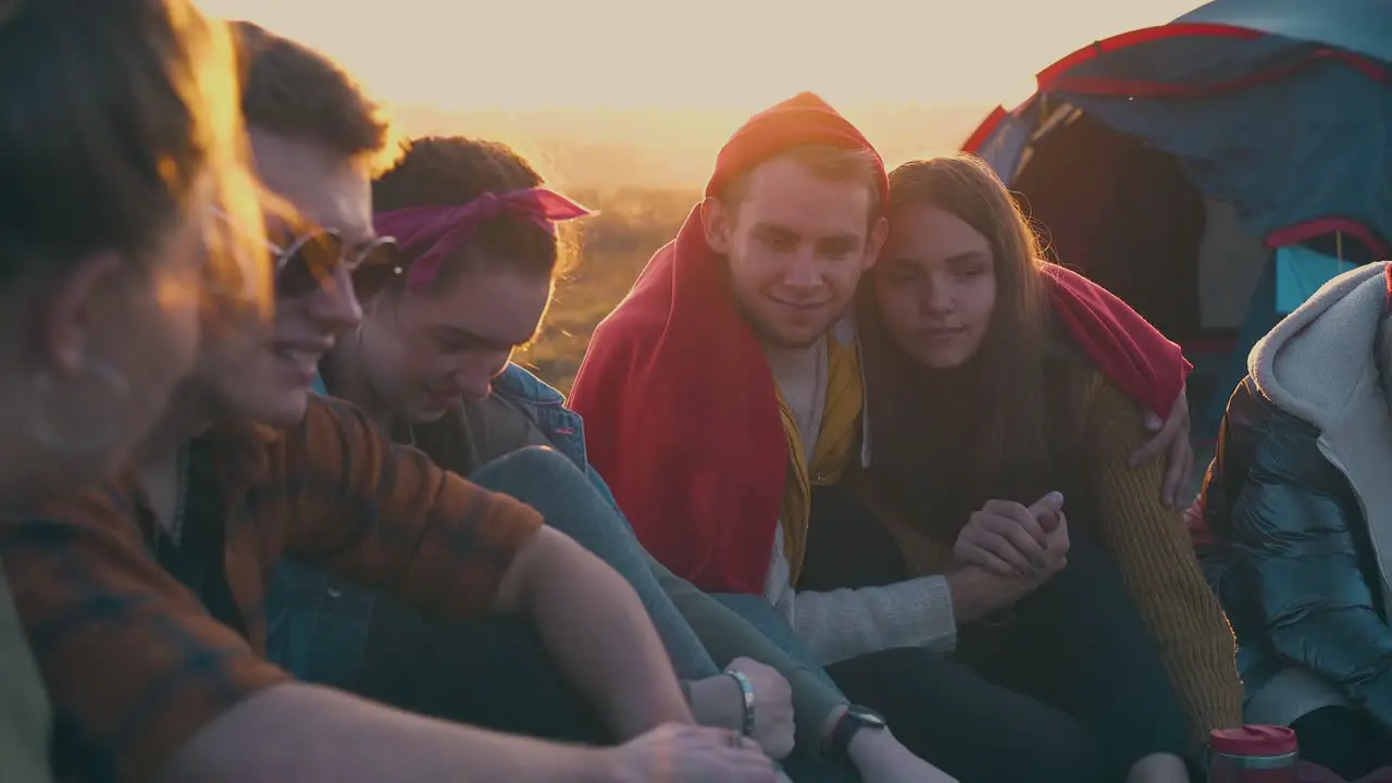 happy people spend time talking at camp bonfire at sunset