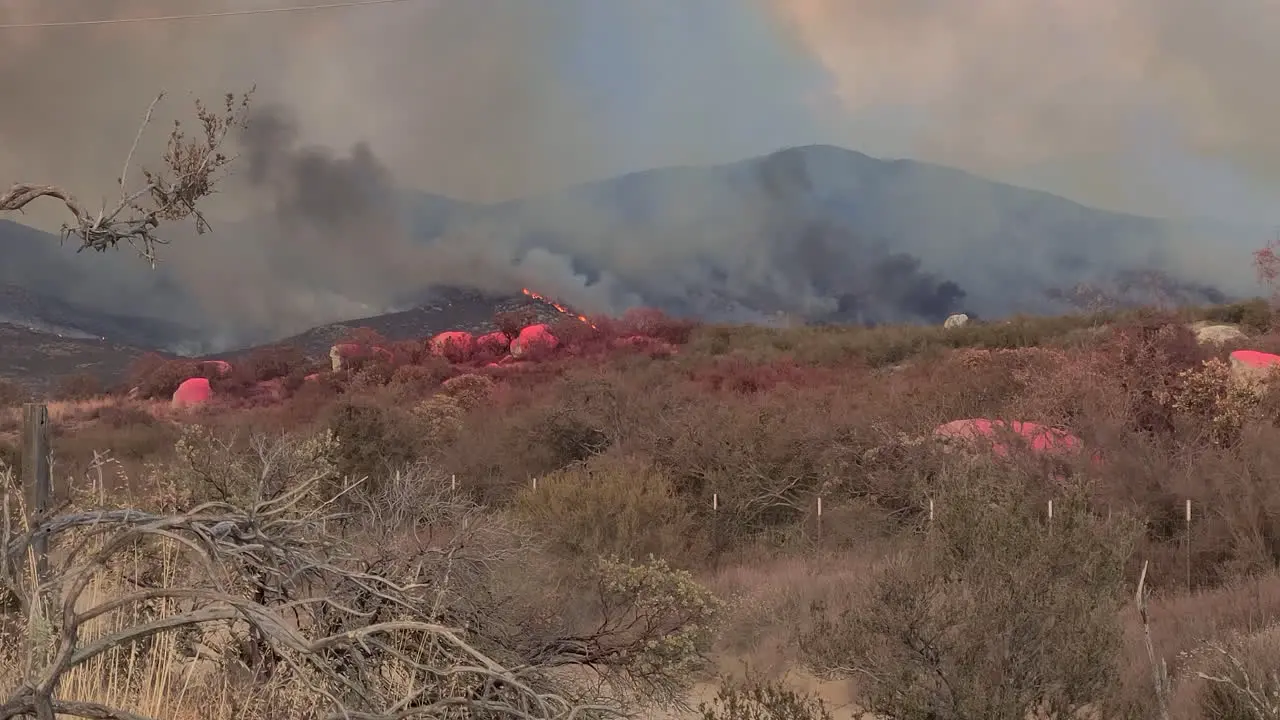 Police Vehicle Moving on Rural Countryside Road Under Wildfire and Smoke From Hilltop Fairview California USA