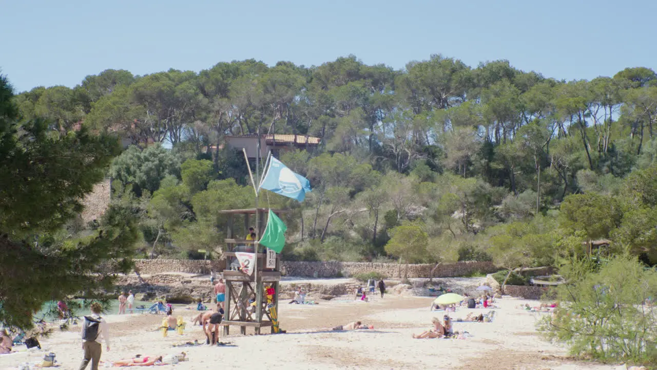 A sunny day at Cala Mondrago beach in Mallorca Spain with people lounging and enjoying the fine sand and the crystal clear water