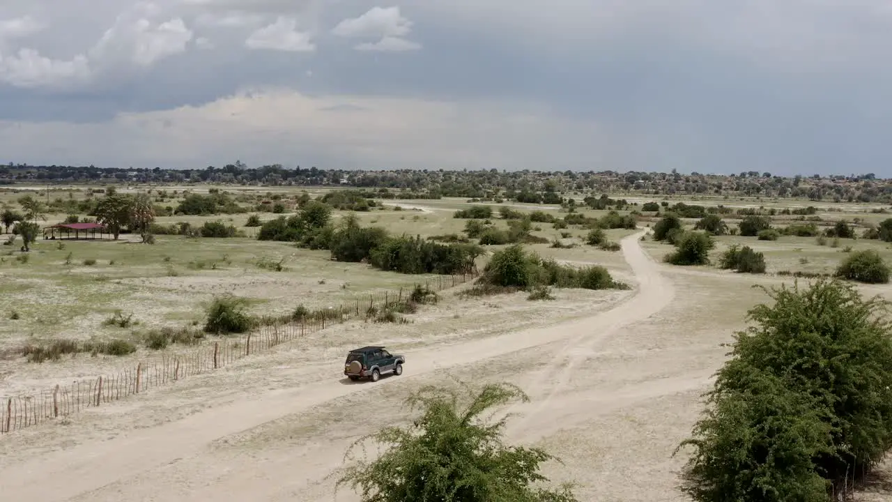 Aerial Safari Jeep Game Driving Tourists On Sunny Morning In African Savanna