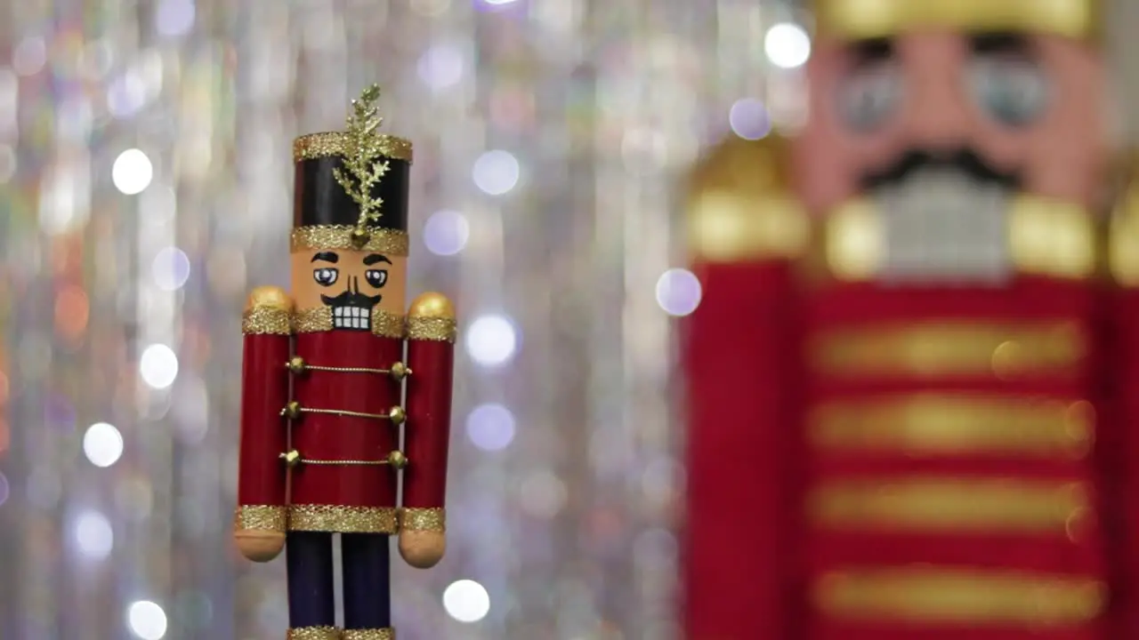 Toy soldier nutcracker next to same huge figurine in bokeh background