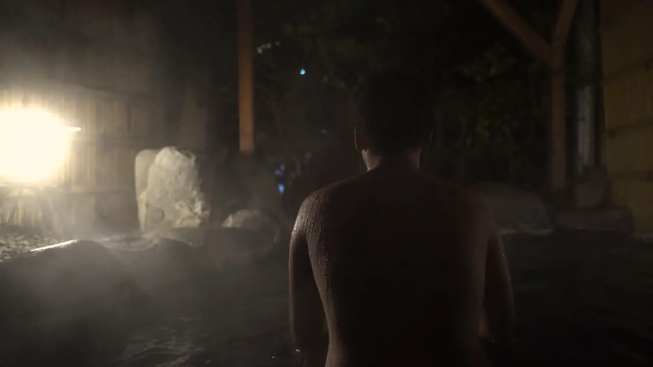 Back View of A Young Female In Outdoor Hot Spring Bath in Japan During Nighttime- Close Up Shot