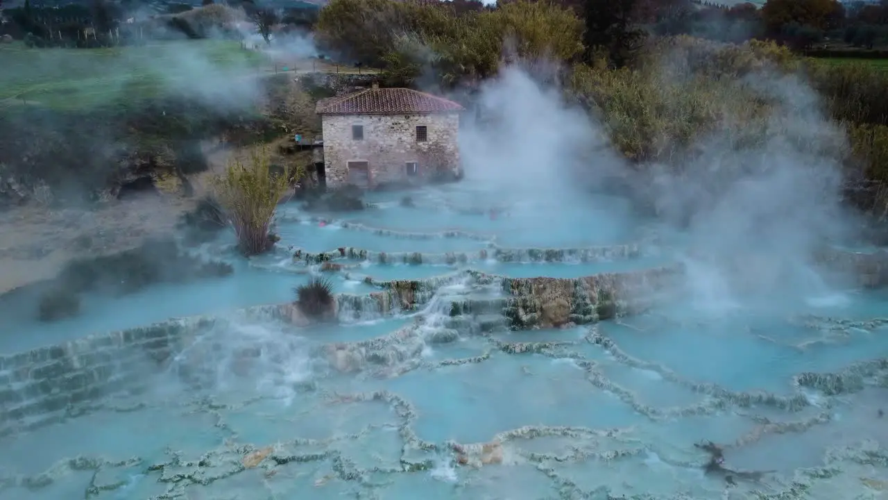 Flying through fog at the thermal hot springs bath and waterfall at Saturnia Tuscany Italy close to Siena and Grosseto