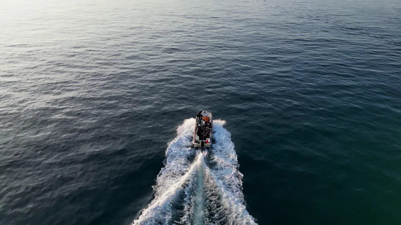 drone following a speedboat racing over calm ocean waters