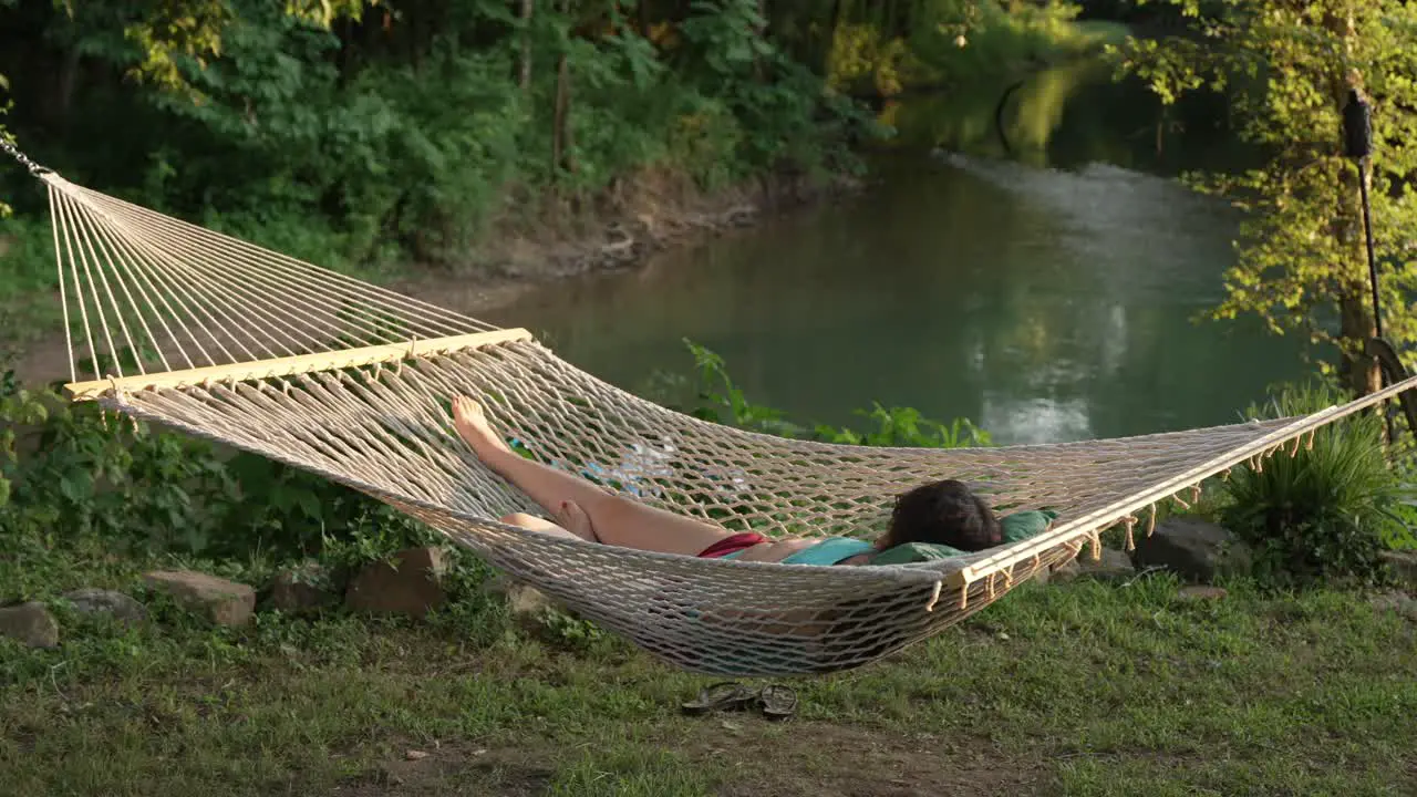 Girl relaxing in a hammock by the Eleven Point River in Thomasville Missouri