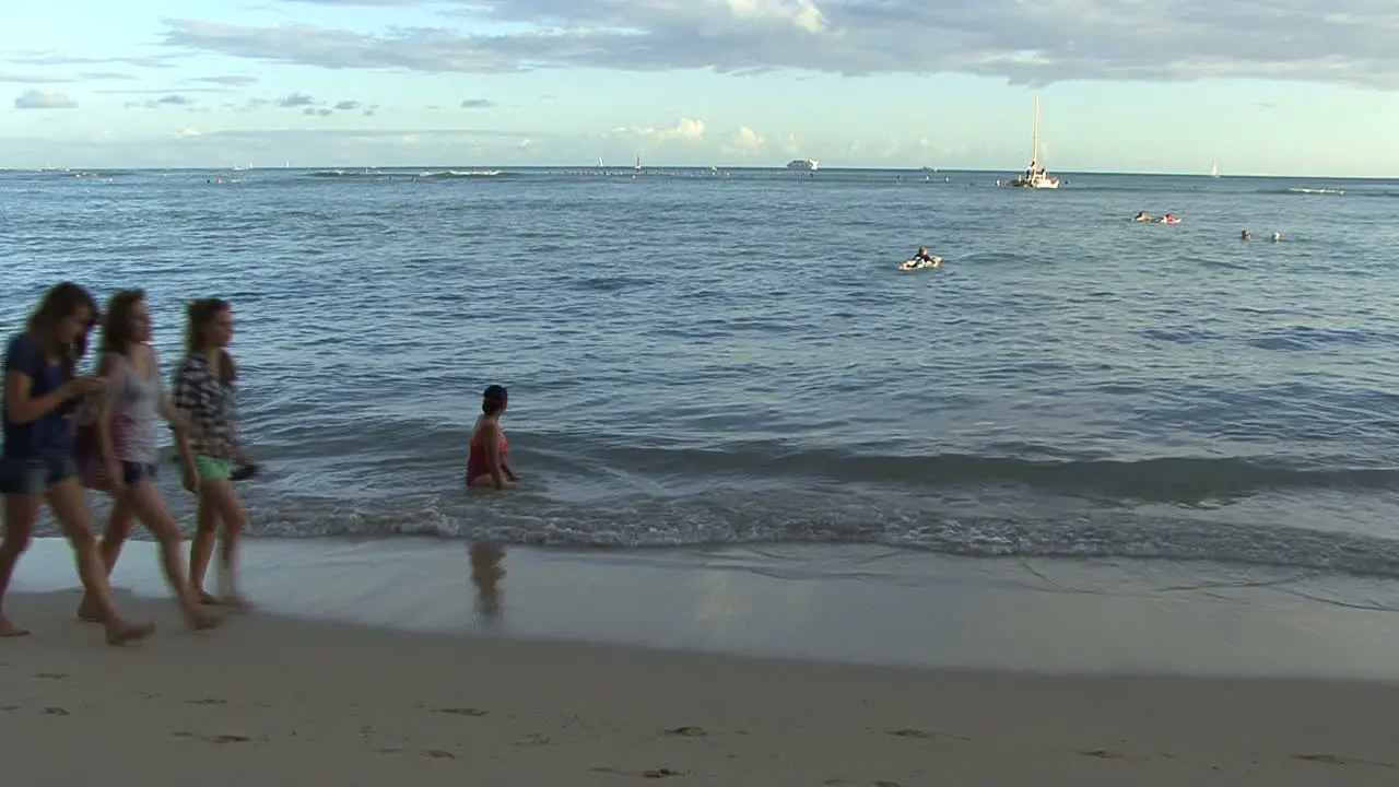 Waikiki girls walk along beach