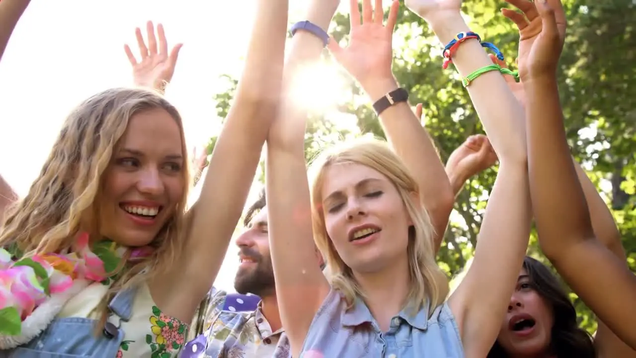 Animation of red shapes over happy people dancing outdoors