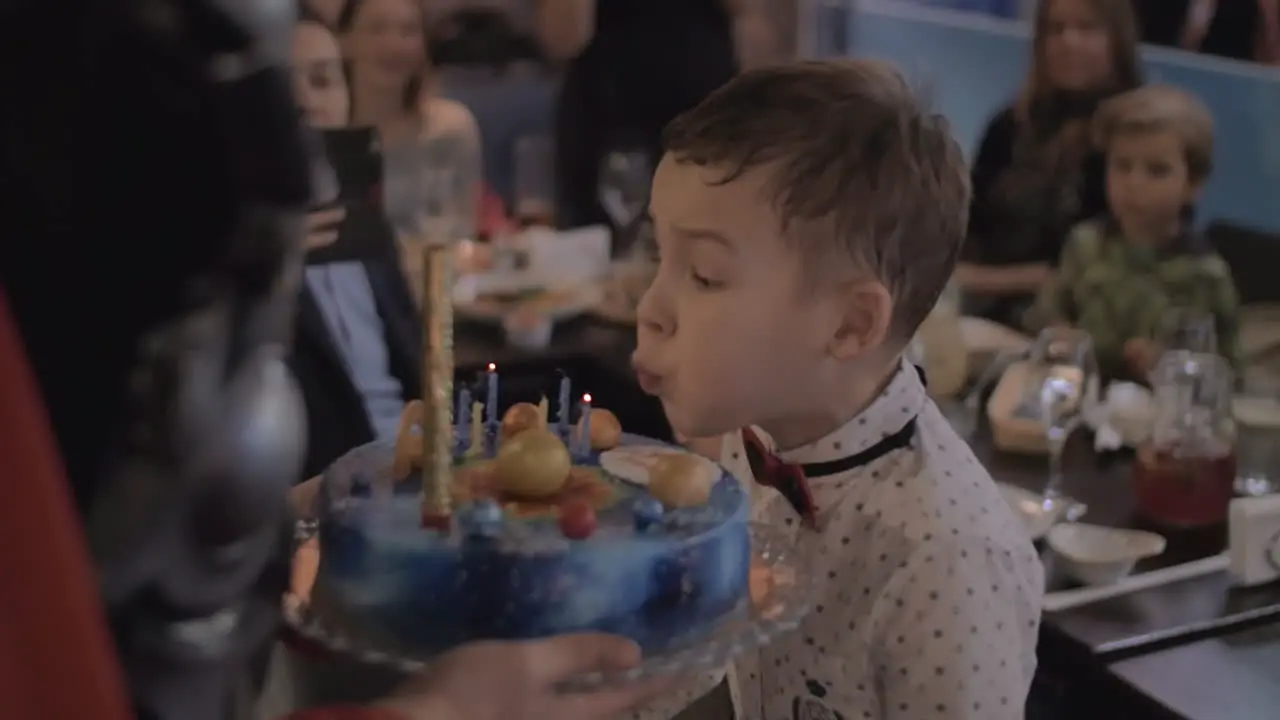 Birthday celebration Child blowing candles on cake