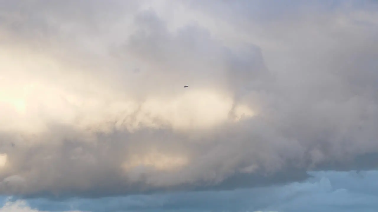 Scene of clouds in sky and plane passing by