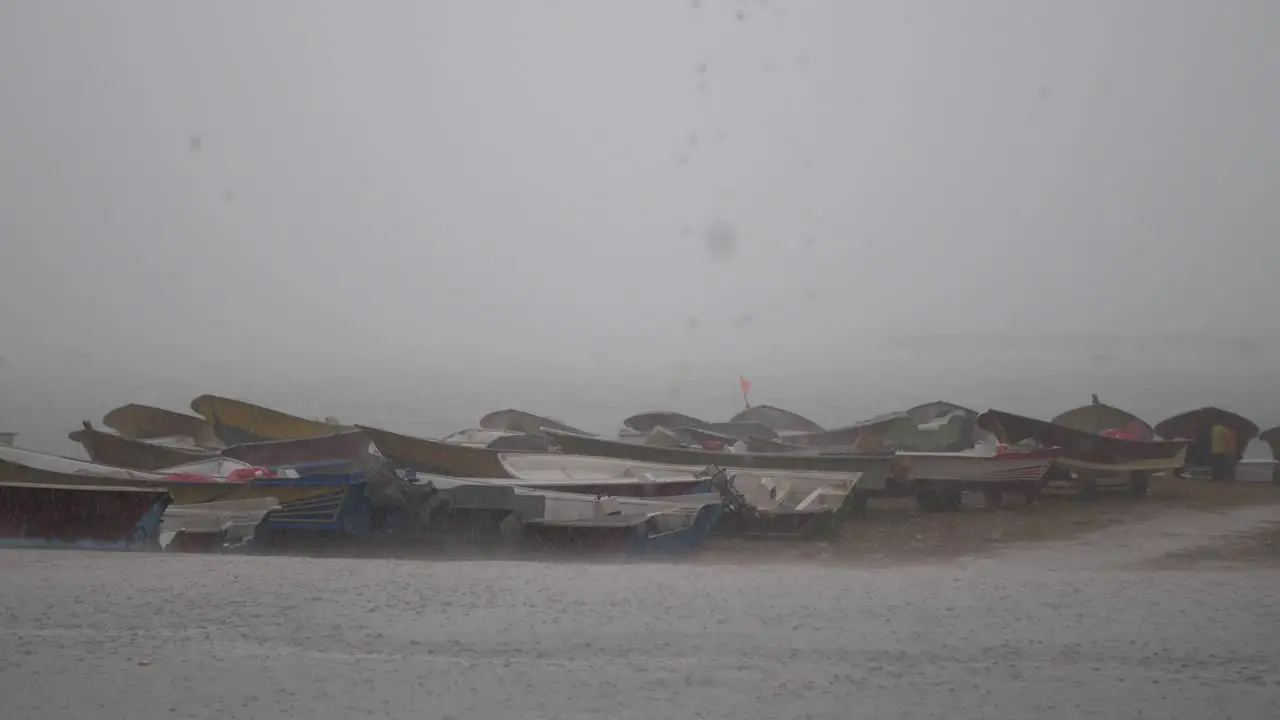 Row Of Empty Small Fishing Boats Resting On Gwadar Beach During Heavy Downpour Rain