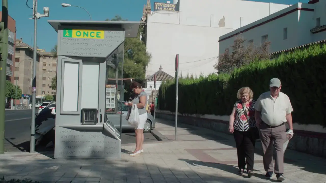 Woman buying fundraising lottery ticket from ONCE kiosk in Spain