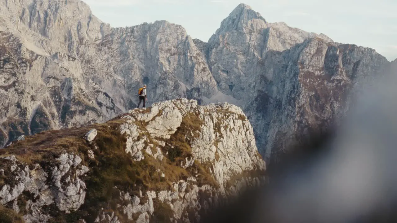 A man walking on the edge of a cliff in the mountains