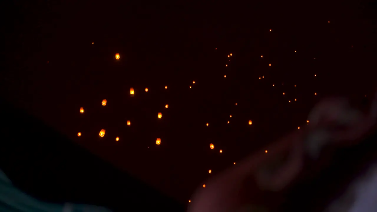 Beautiful paper sky lanterns floating in sky at night