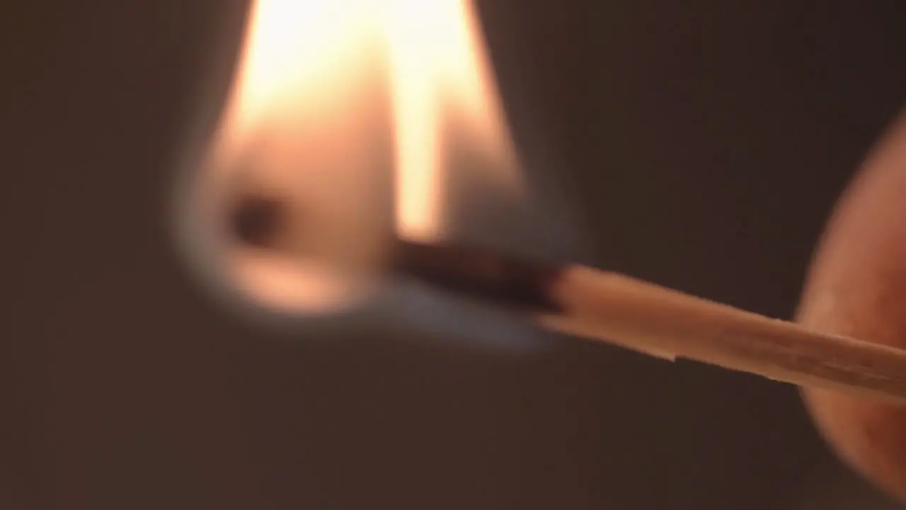 Hand holding a burning match