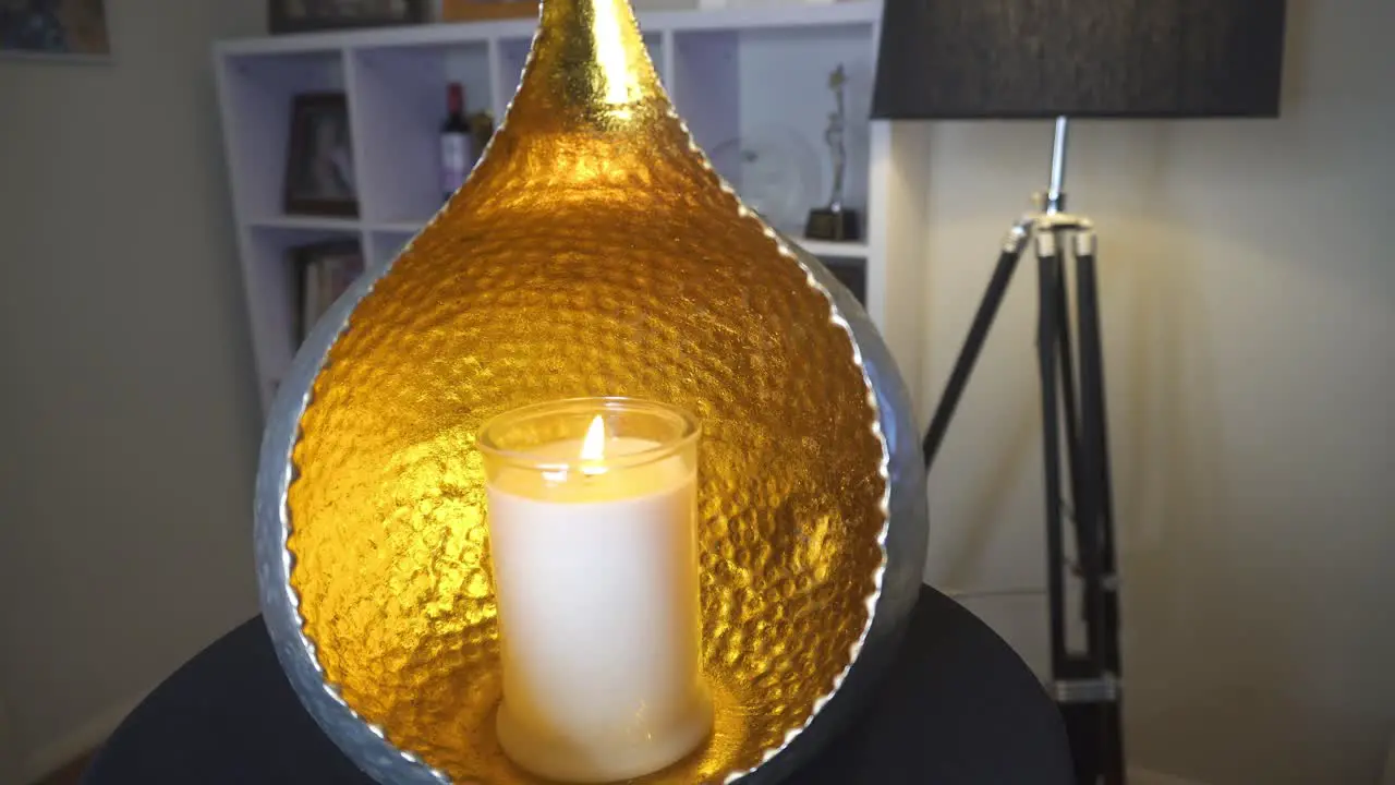 Orb candle holder with flickering candle slow pan in living room Calming