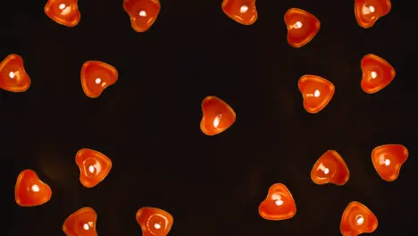 Overhead Shot Of Romantic Lit Heart Shaped Red Candles Revolving On Black Background Flickering