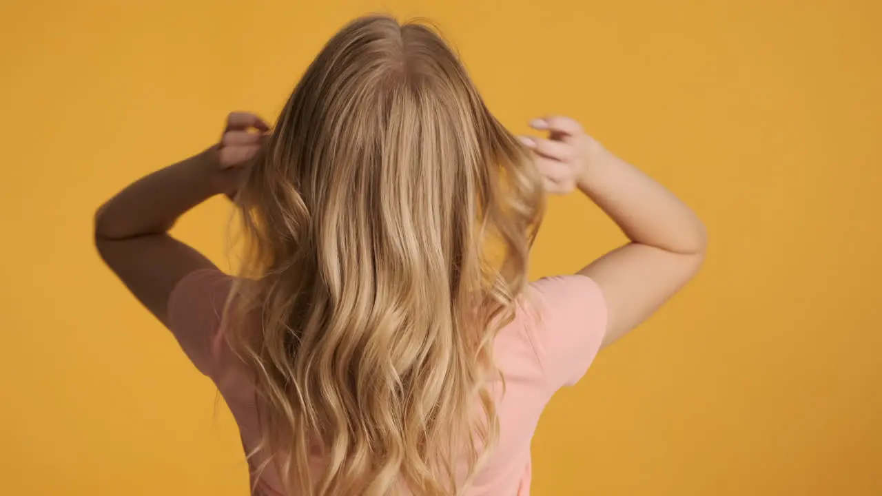 Caucasian woman waving hair on camera