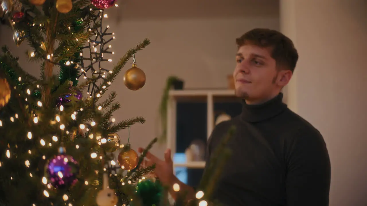 Man decorating Illuminated Christmas tree