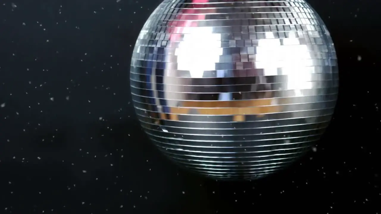 Animation of snow falling over glowing mirror disco ball