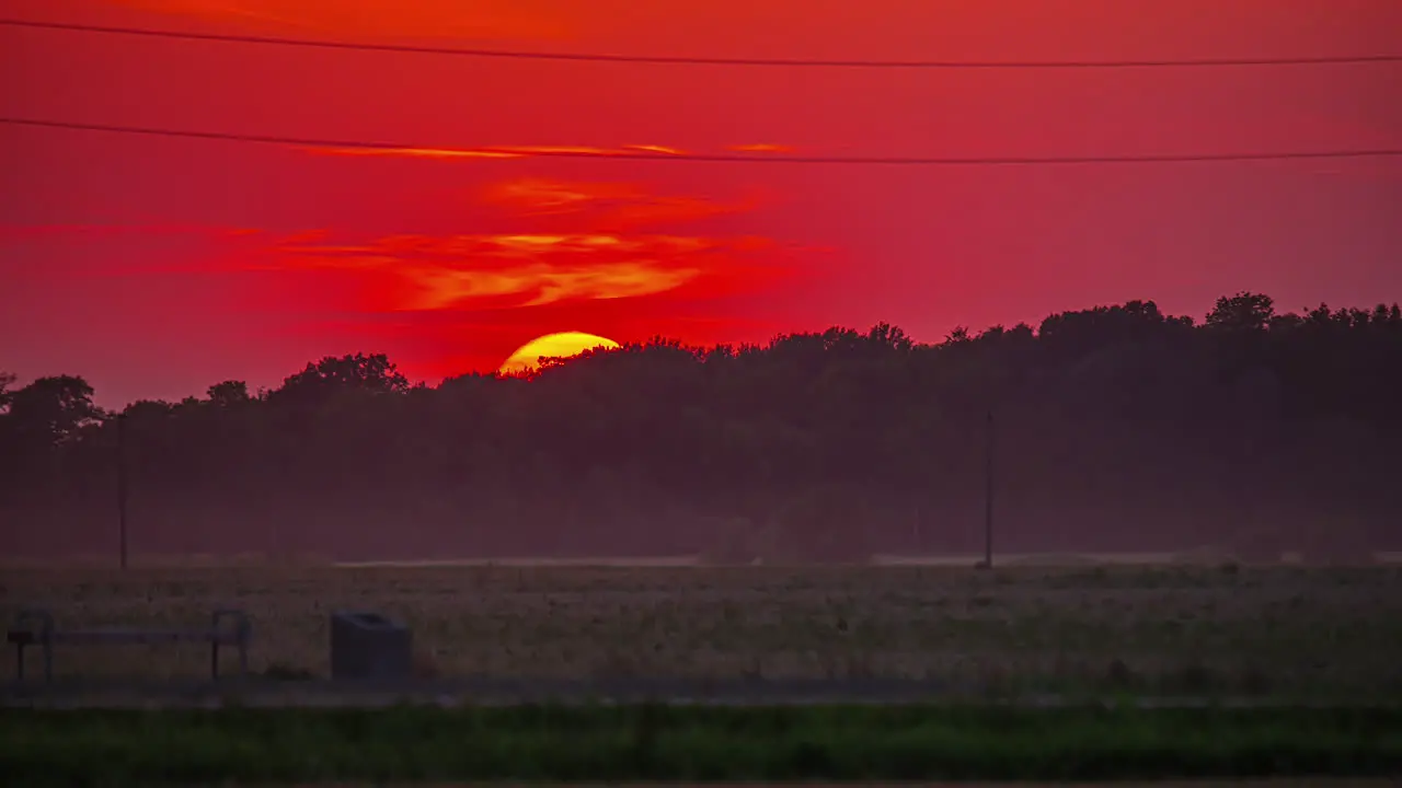 Golden Sun Setting Down Over Dark Field Against Fiery Sunset Sky