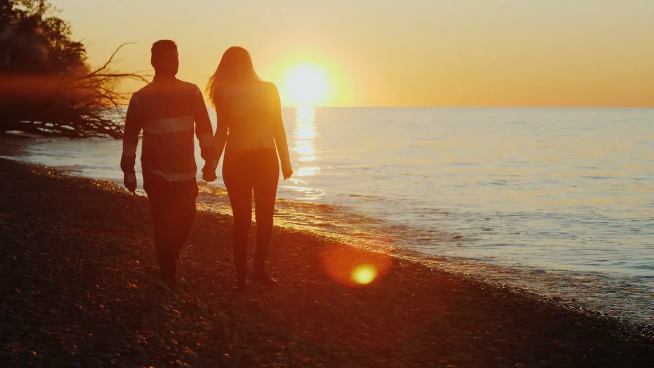 Couple Walking on Beach at Sunset