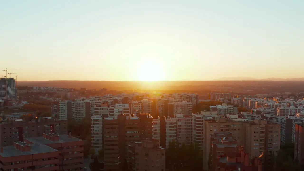 Forwards fly above residential district in town Tall apartment houses in housing estate View against colourful sunset