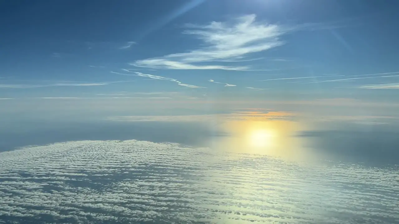 Nice aerial view from a jet cockpit of a beautiful sky with the sun reflected on the sea