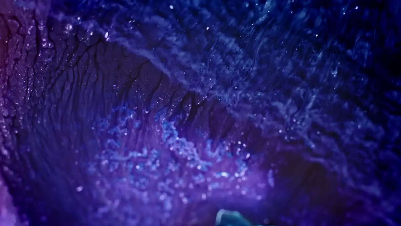 Close-up of vibrant blue and purple ink diffusing in water creating an abstract fluid art scene