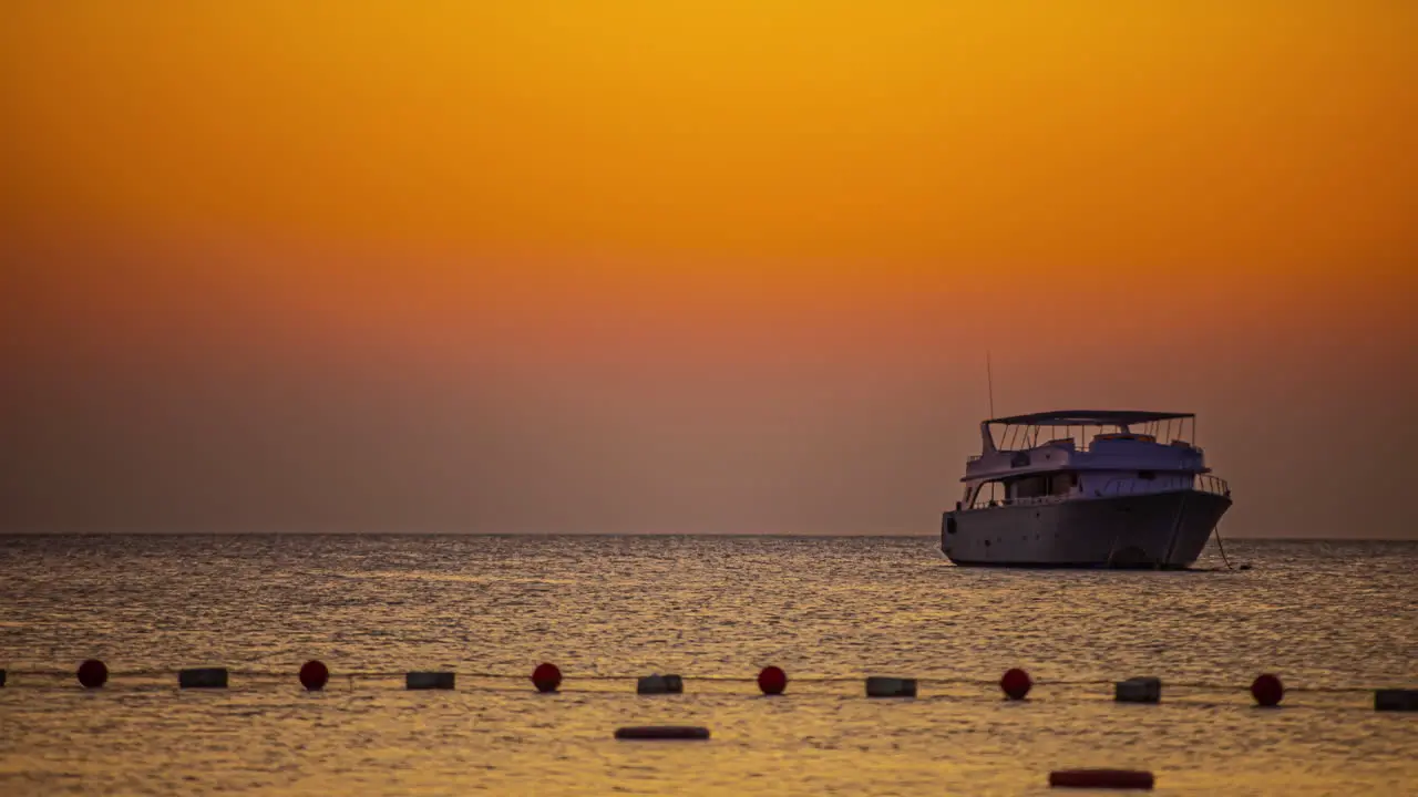 Anchored on Ocean during orange colored sky time lapse shot