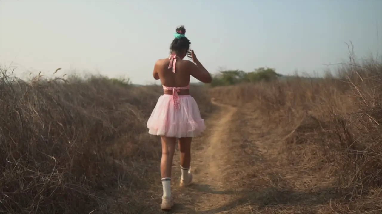 Trendy looking girl walking in a pink skirt elegant outfit sun is shining