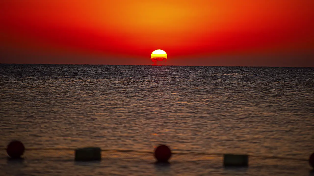 Time lapse shot of golden sunset behind sea at horizon in the evening wide shot