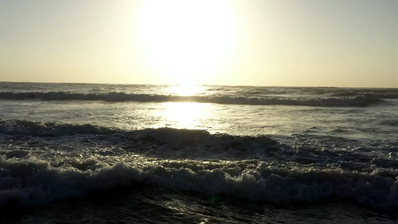 AERIAL Golden Sunrise Low Over Crashing Ocean Waves