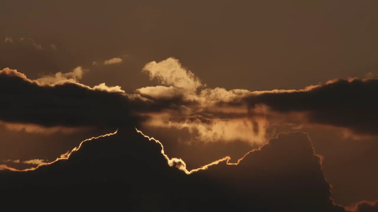 Time lapse of sun setting behind clouds at sunset static wide shot