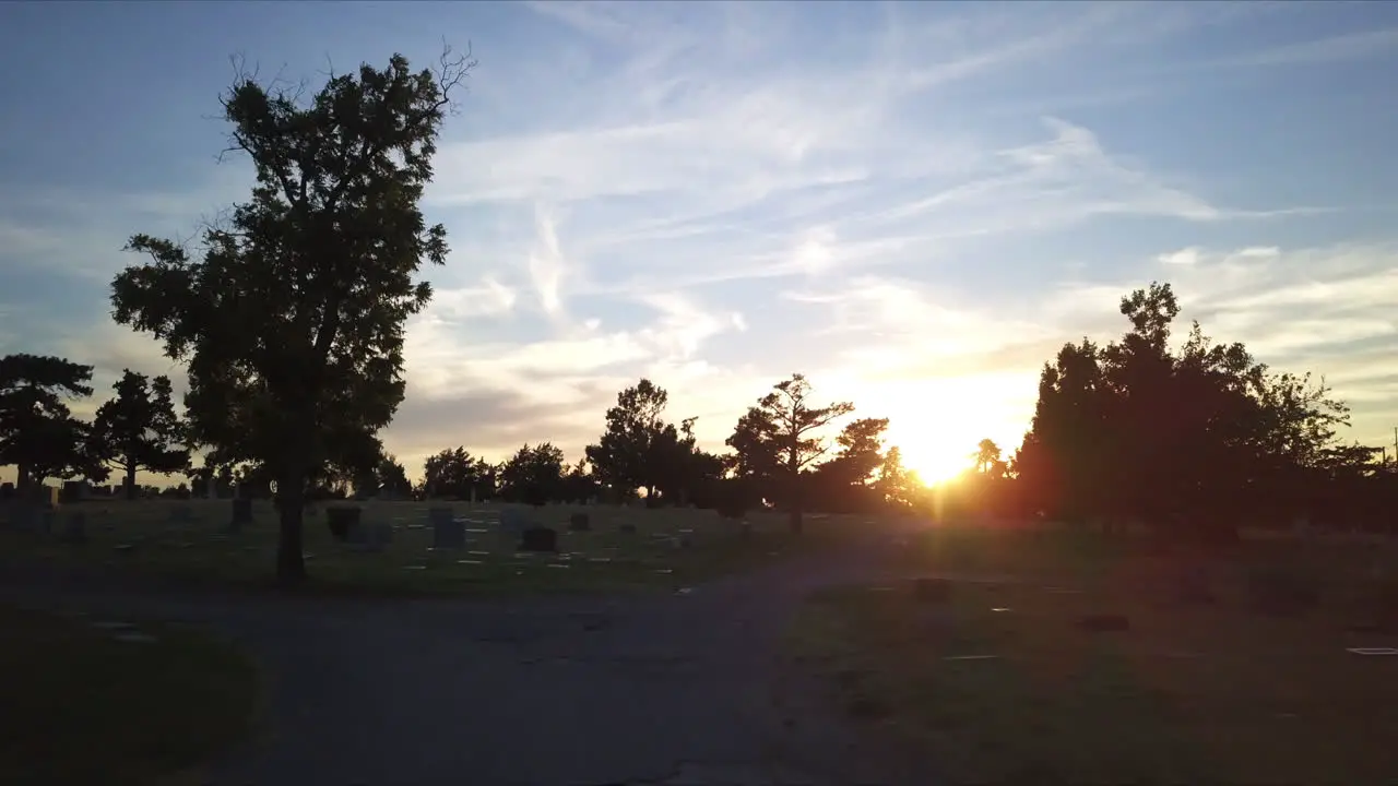 Slow aerial dolly through a cemetery during sunset