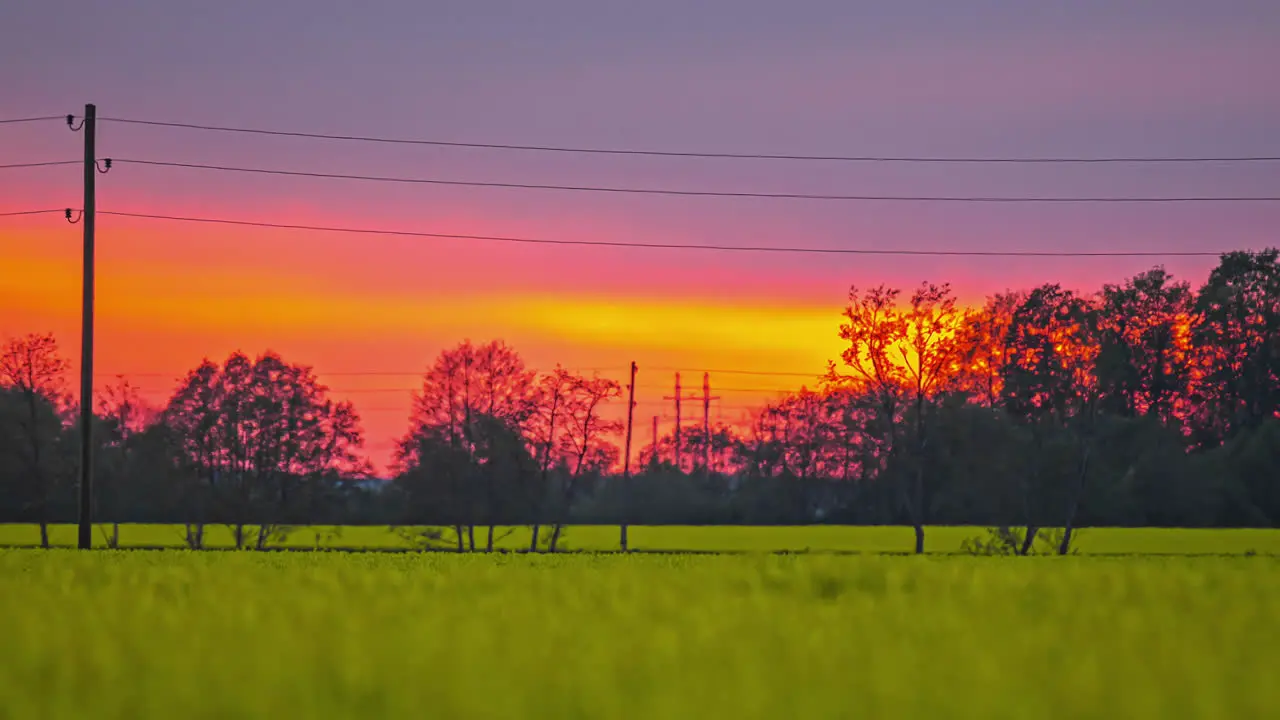 Fiery sunset sky glowing above agriculture fields telephoto zoom fusion time lapse