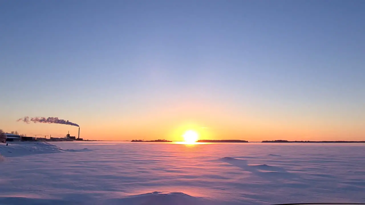 Majestic orange sunset over snowy winter flatlands in Finland