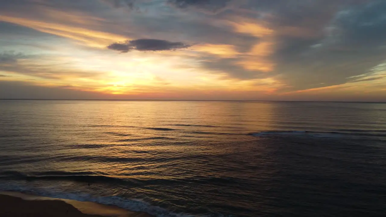 Drone pan shot with morning painted reflective sunrise over ocean waves Forresters Beach Central Coast NSW Australia 3840x2160 4K