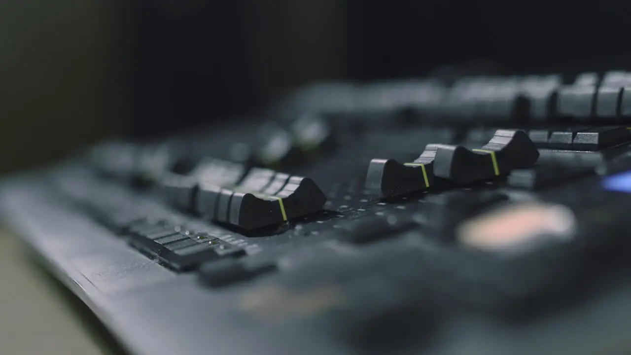 Adjusting the light levels using a lighting desk panel in a studio close up