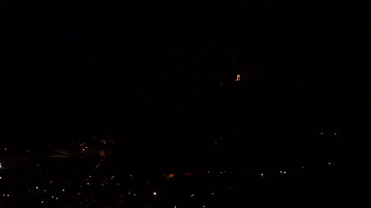 Celebration with colorful and sparkling fireworks over a mountain town at night