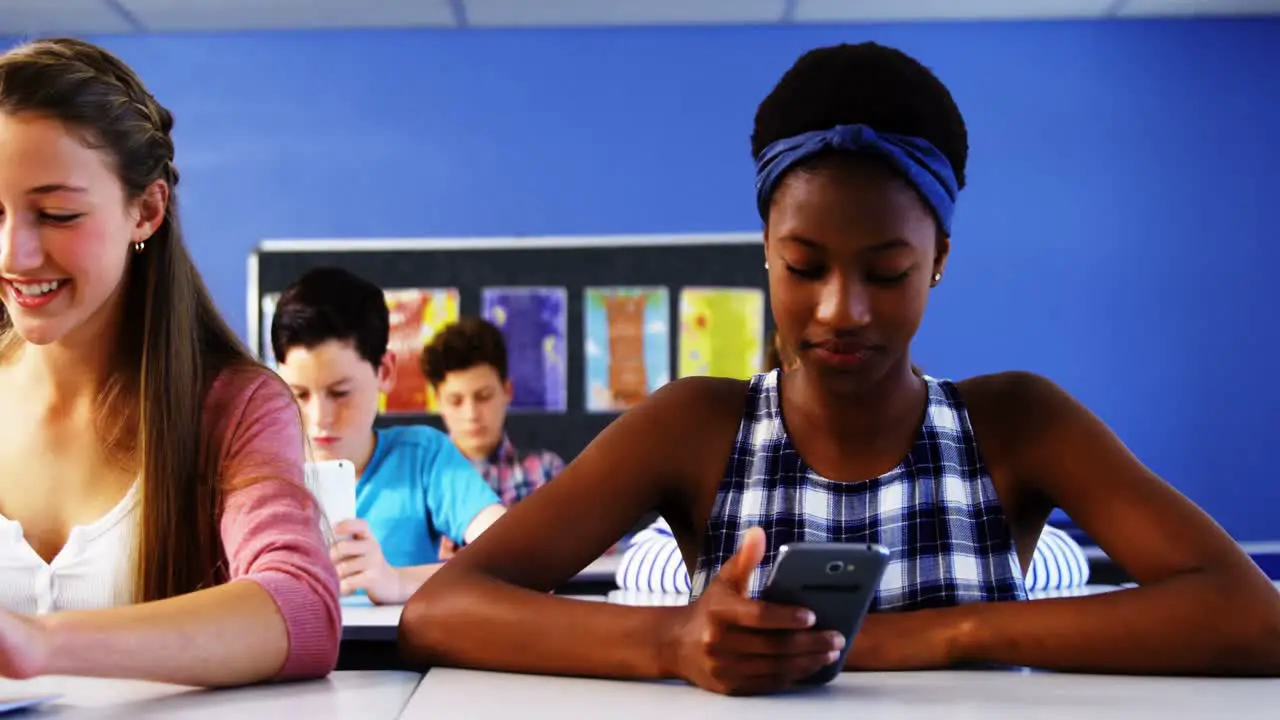 Students using laptop and mobile phone in classroom