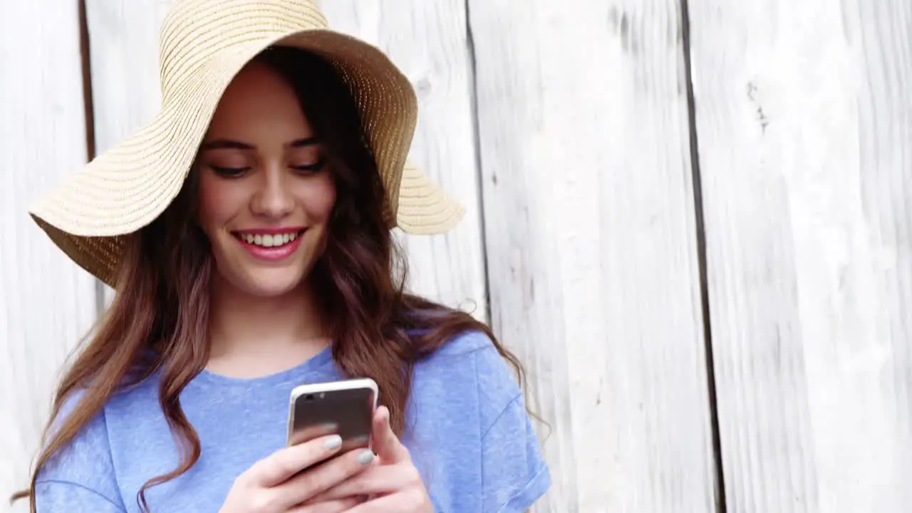 Beautiful woman in hat using mobile phone