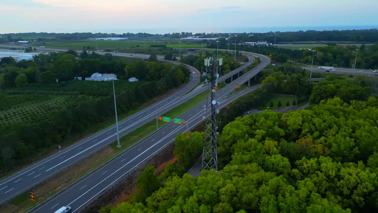 Orbital aerial view of cell phone tower reveals farmland beyond the highway