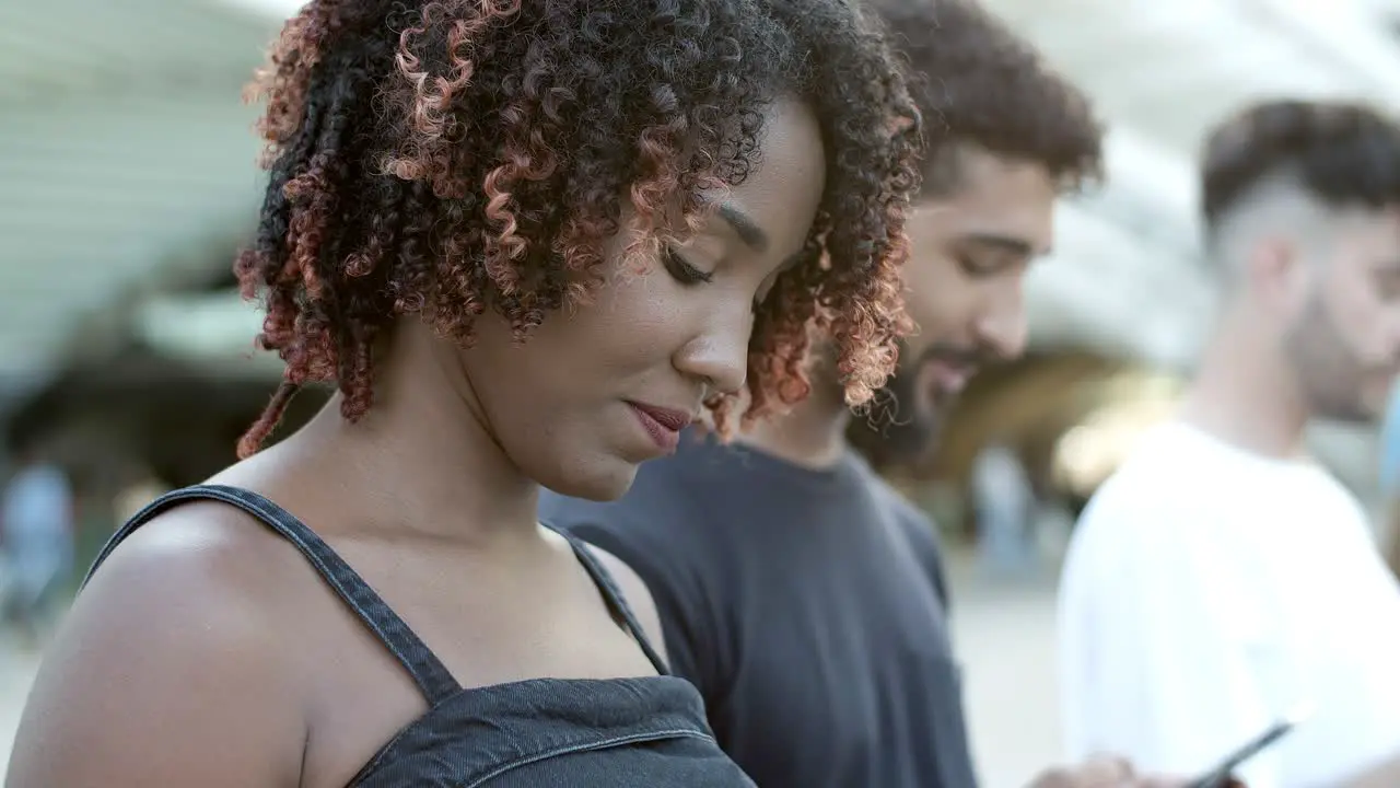 Cheerful African American lady texting with smartphone