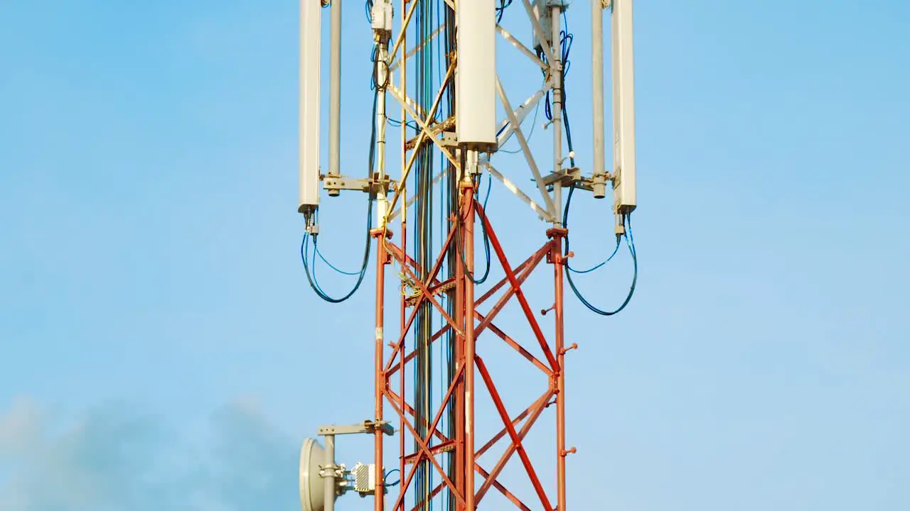 Tilt Up Shot of cell tower against blue sky background in Curacao