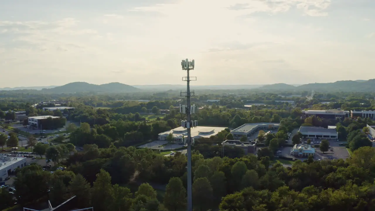 Aerial orbiting 5G cell phone radio communication tower in suburban area 4K