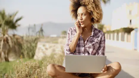 Young African Woman Working On Laptop In Nature